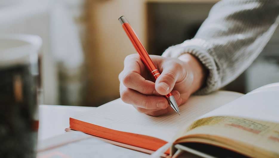 person writing in note book