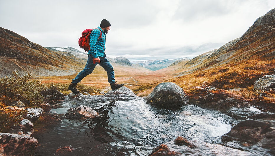 man walking over stream