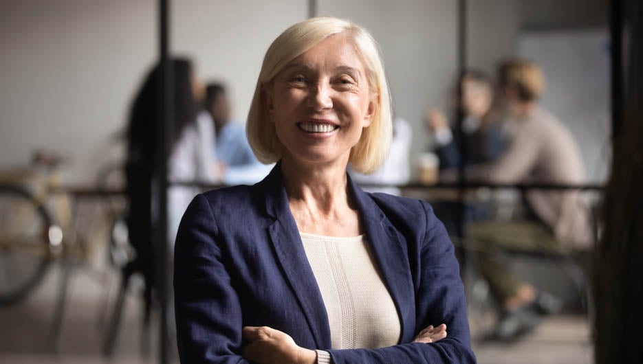 Happy mid aged business woman manager handshaking greeting clien