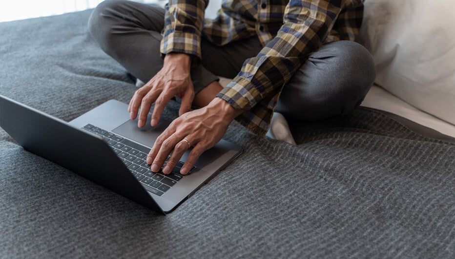 man in bed with laptop