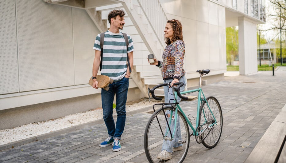man with skateboard and woman with bicycle